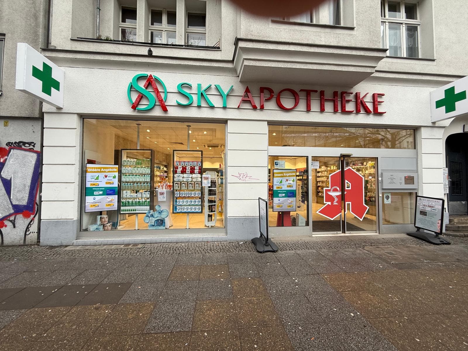 Zwei Hochformat-Displays im Schaufenster der Sky Apotheke Wedding in Berlin